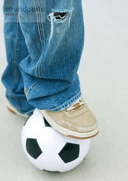 Junge ruht Fuß auf Fußball  Nahaufnahme