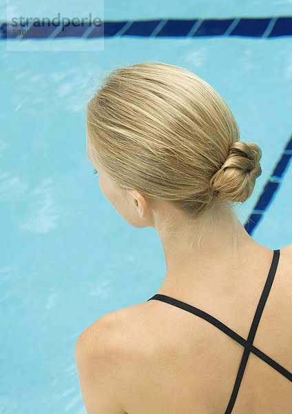 Frau mit Blick auf den Pool  Rückansicht