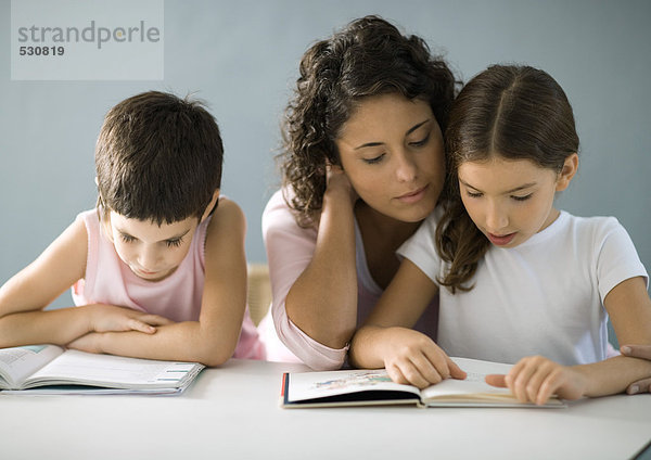 Mutter hilft Kindern bei den Hausaufgaben