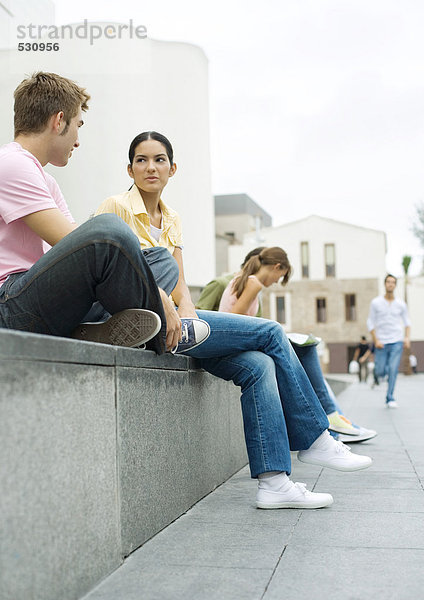 Teens sitzen im Freien im Stadtgebiet