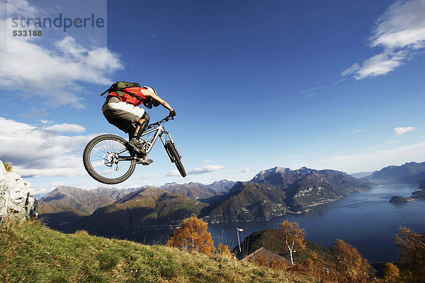 Italy  Lake Como  man performing jump on bicycle