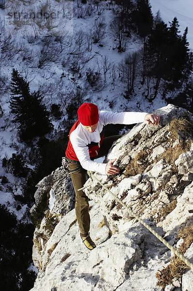 junge Frau  die auf den Felsen klettert.