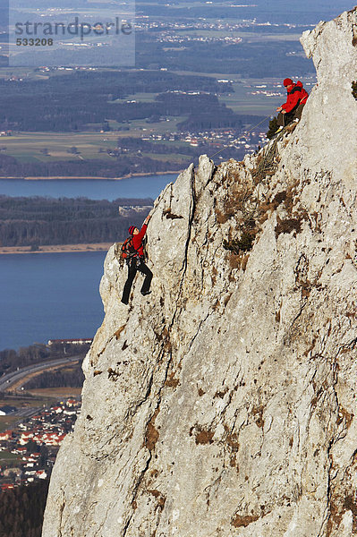 Deutschland  Bayern  zwei Personen beim Klettern an der Felswand