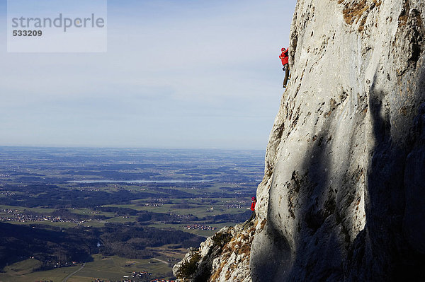 Deutschland  Bayern  zwei Personen beim Klettern an der Felswand