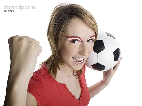 Frau mit österreichischer Flagge auf Augenbrauen  die Fußball halten