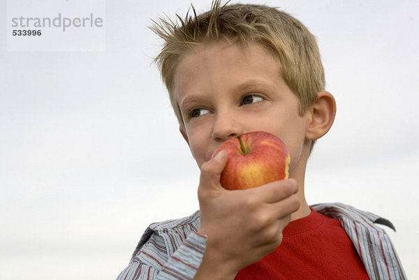 Junge (10-12) isst Apfel  Nahaufnahme