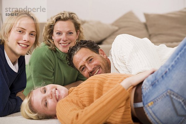 Familie auf dem Boden liegend im Wohnzimmer