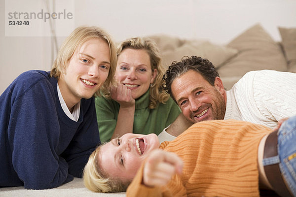 Familie auf dem Boden liegend im Wohnzimmer