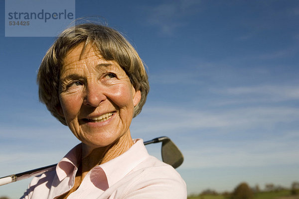 Ältere erwachsene Frau mit Golfschläger