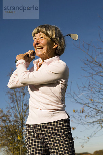 Ältere erwachsene Frau mit Golfschläger