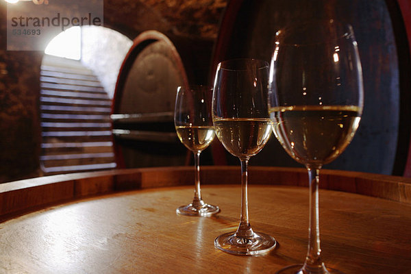 Weißwein im Glas auf Weinfass