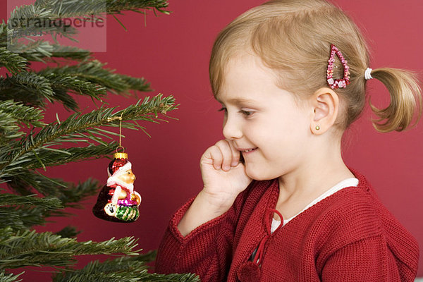 Kleines Mädchen am Weihnachtsbaum