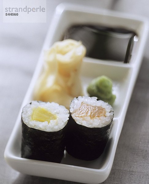 Zwei Maki-Sushi mit Wasabi  eingelegtem Ingwer und Sojasauce