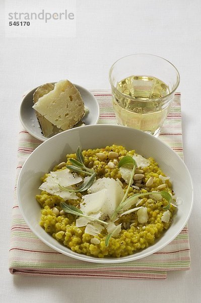 Risotto mit Salbei  Pinienkernen und Parmesan  Glas Weisswein