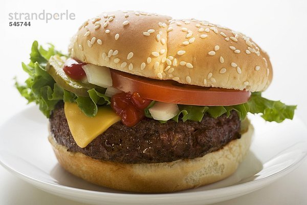 Cheeseburger mit Tomate  Zwiebeln  Ketchup und Essiggurke