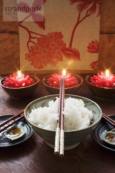 Schale Reis vor brennenden Kerzen (Thailand)