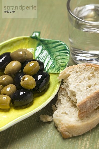 Oliven  Weissbrot und Glas Wasser