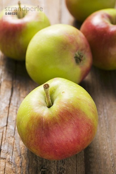 Mehrere frische Äpfel auf Holzuntergrund