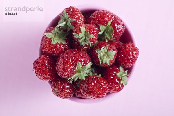 Frische Erdbeeren im rosa Becher von oben