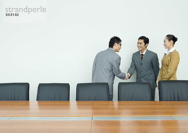 Geschäftspartner beim Händeschütteln im Konferenzraum
