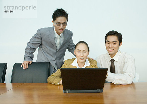 Drei Geschäftspartner mit Laptop