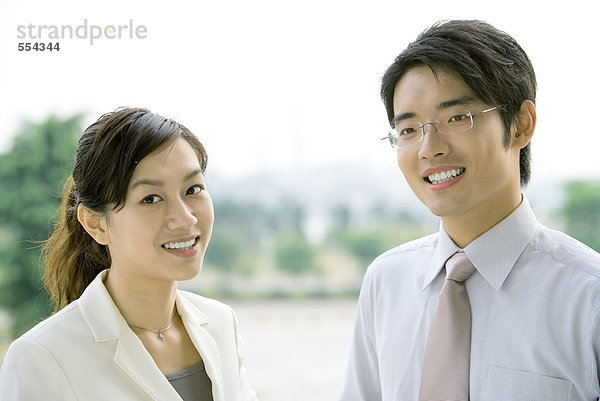 Zwei Geschäftsleute  lächelnd vor der Kamera  Kopf und Schultern  Portrait