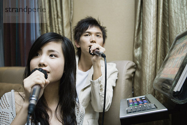 Junges Paar singt Karaoke