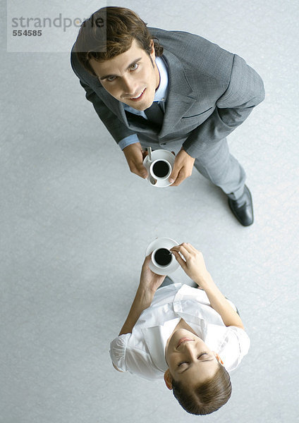 Männliche und weibliche Mitarbeiter mit Kaffee  volle Länge  hoher Blickwinkel