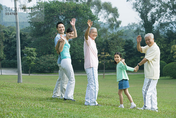 Drei Generationen Familie winken vor der Kamera