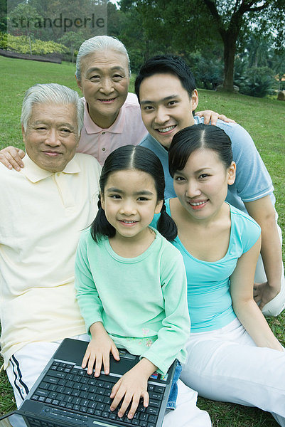 Drei Generationen Familie mit Laptop  Portrait