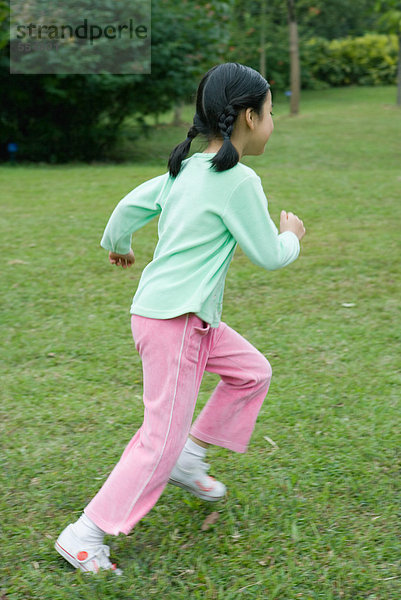 Kleines Mädchen rennt über das Gras
