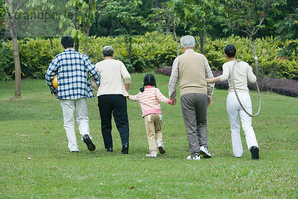 Drei Generationen Familie  gemeinsam gehen  Rückansicht