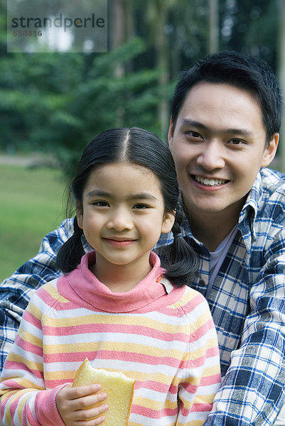 Vater und Tochter  Mädchen mit Brotscheibe  Porträt