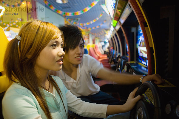 Teenager-Paar beim Spielen in der Videospielhalle
