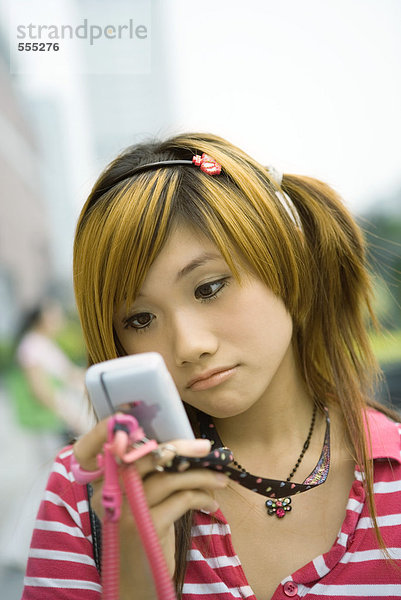 Teenager-Mädchen schaut auf Handy  Stirnrunzeln