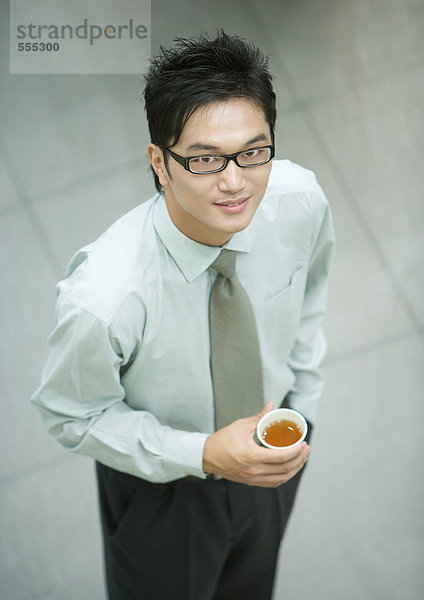 Geschäftsmann stehend  Tasse Tee haltend  lächelnd vor der Kamera  hoher Blickwinkel