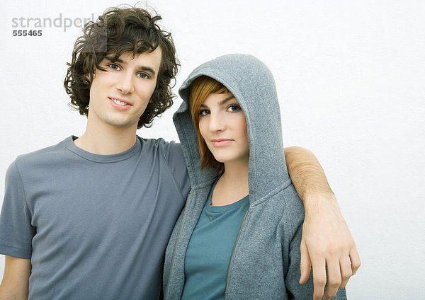 Junges Paar  Mann mit Arm um die Schultern der Frau  Portrait