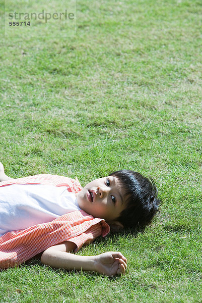 Junge auf Gras liegend