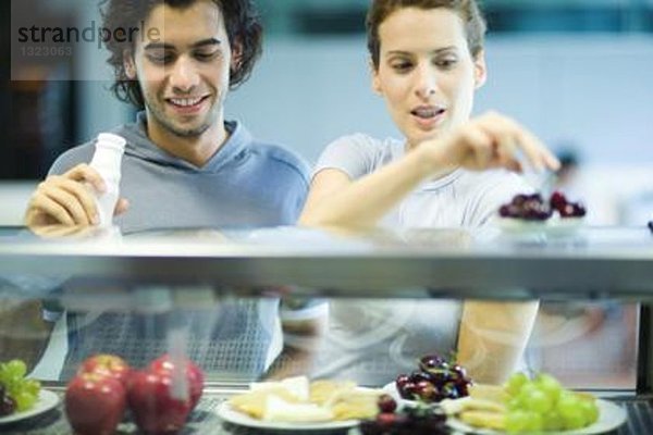 Junge Erwachsene in Sportbekleidung  Snack in der Cafeteria des Fitnessclubs