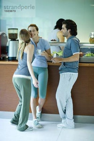 Junge Erwachsene in Sportbekleidung  Pause in der Cafeteria des Fitnessclubs