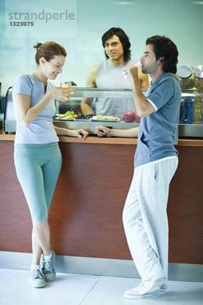 Junge Erwachsene in Sportbekleidung  Pause in der Cafeteria des Fitnessclubs