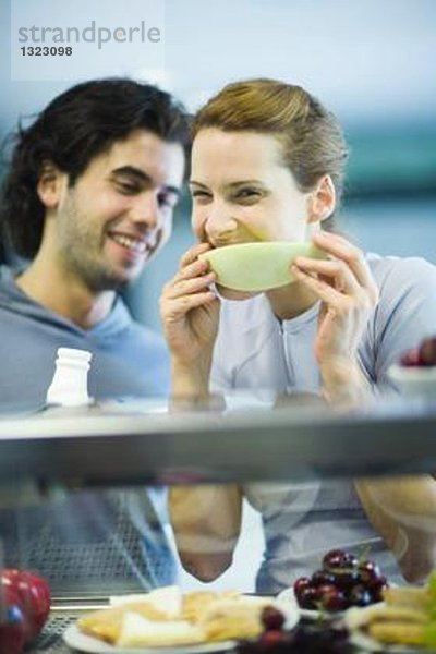 Junge Erwachsene in Sportbekleidung  Snack in der Fitness-Cafeteria