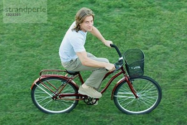 Junger Mann beim Radfahren auf Rasen  hohe Blickwinkel