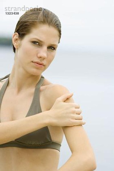 Junge Frau im Badeanzug mit Hand auf Schulter