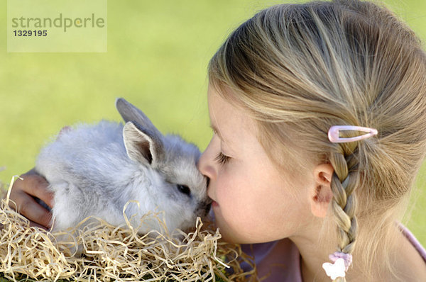 Mädchen (6-7) küssend Osterhase