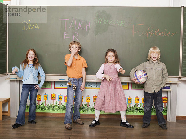 Kinder (4-7) vor der Tafel stehend  Porträt