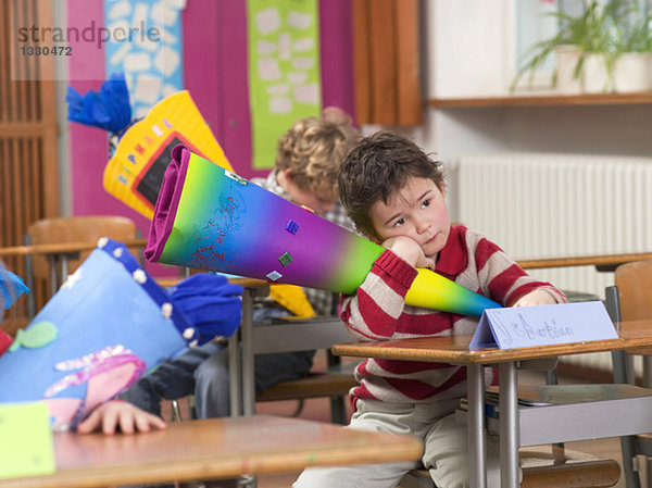 Children (4-7) in classroom  holding school cones