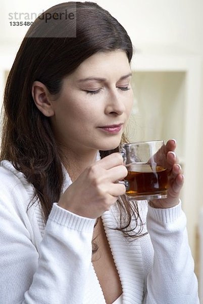 Frau hält eine Tasse Tee in den Händen