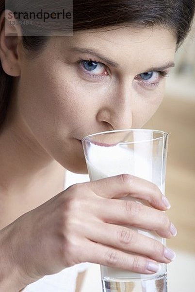 Frau trinkt Milch aus einem Glas