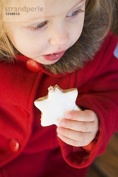 Kleines Mädchen isst Zimtstern